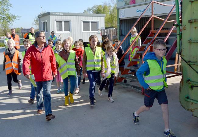 kinderen lopen rond op het recyclagepark