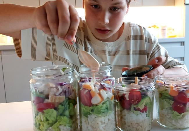 Vince giet saus over de rijstsalade